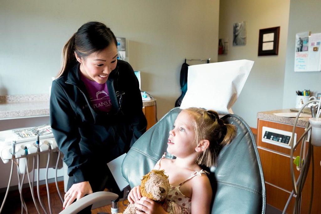 Dental Hygienist Ali talks with a child in the Great Plains Dental office in Sioux Falls