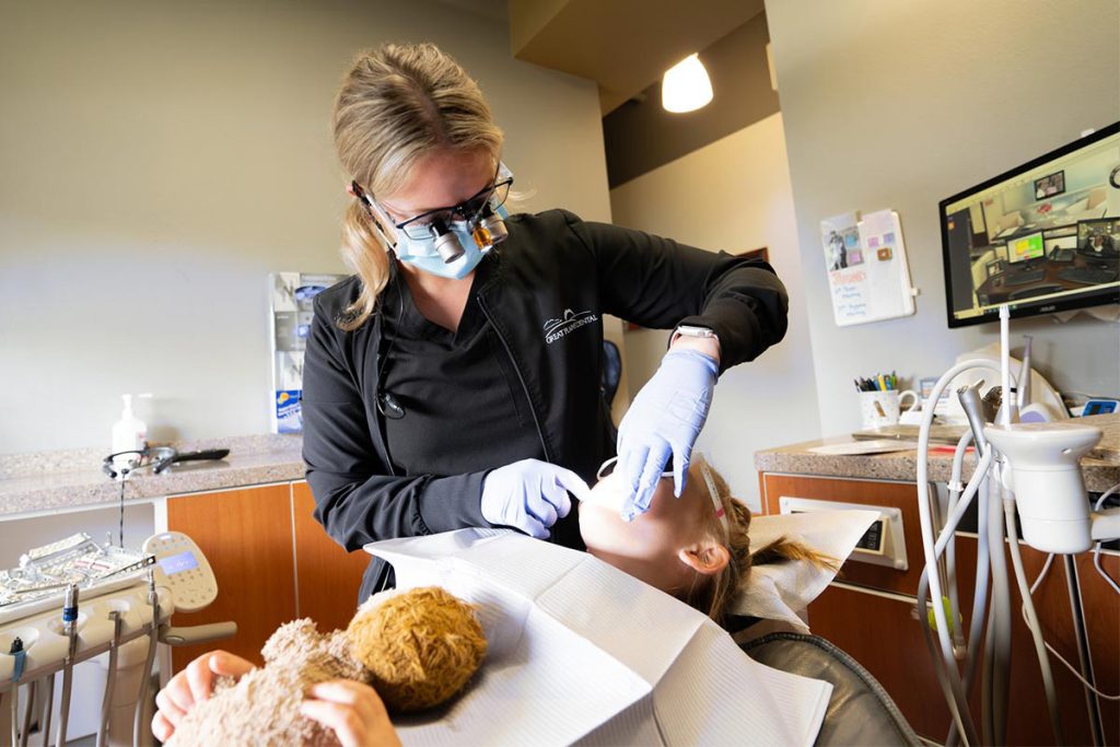 A dentist works with a young patient at Great Plains Dental in Sioux Falls