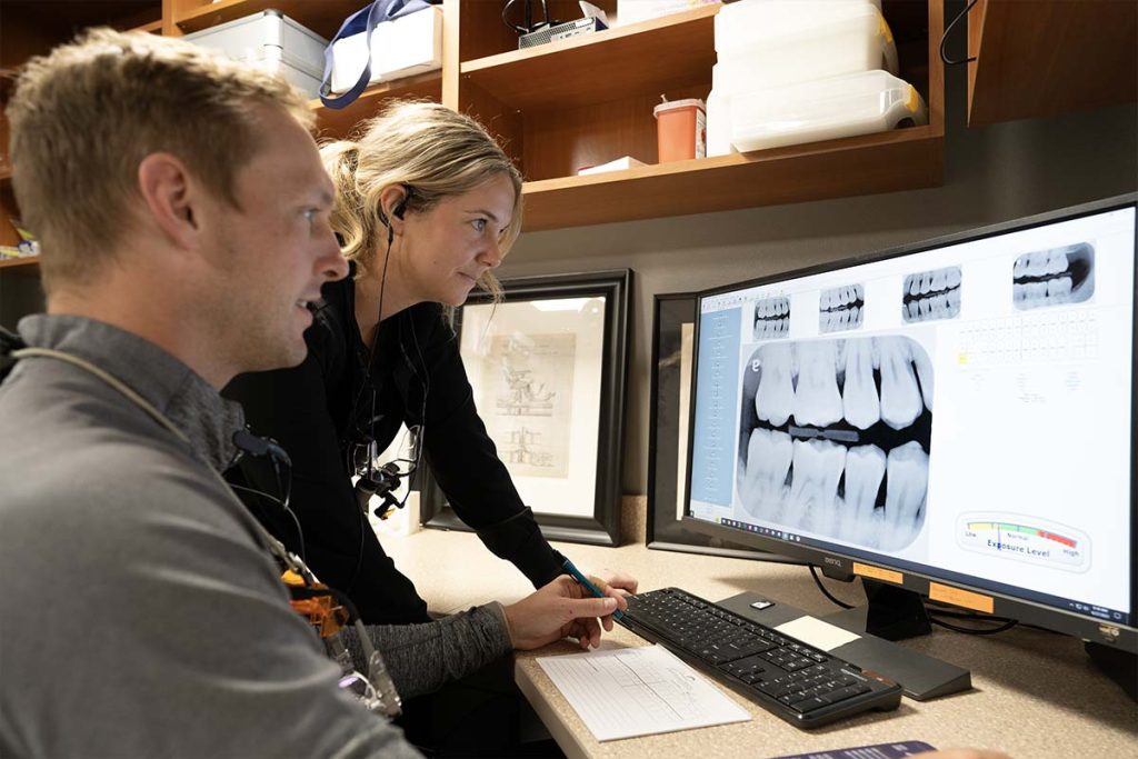 Dr. Brock Nelsen looks at tooth x-rays with an employee at Great Plains Dental in Sioux Falls