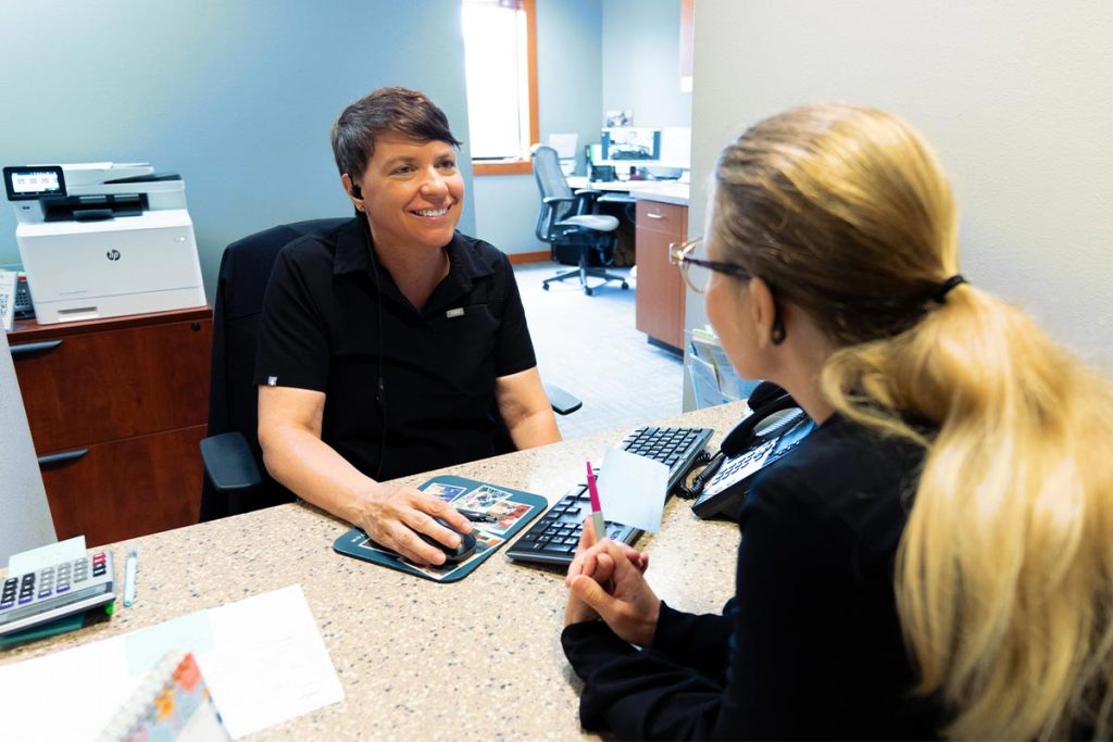 Treatment Coordinator Heather speaks with a client at Great Plains Dental in Sioux Falls