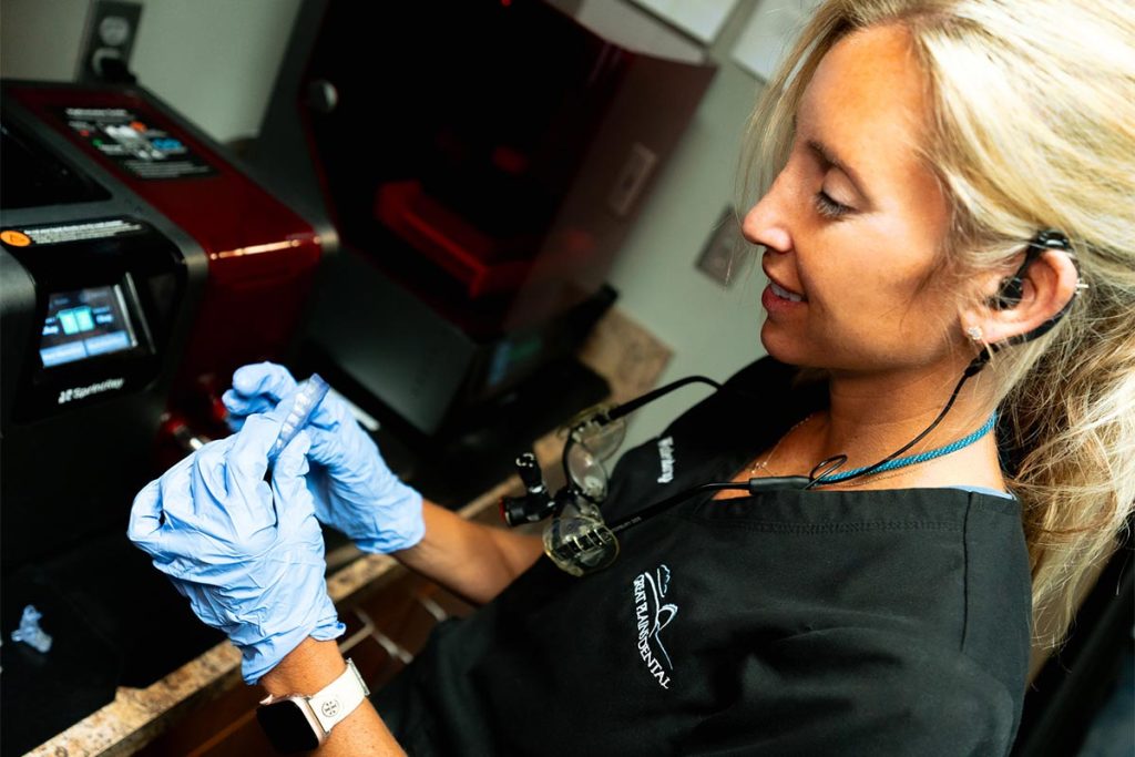 Dr. Jessica Waterbury inspects a retainer at Great Plains Dental in Sioux Falls