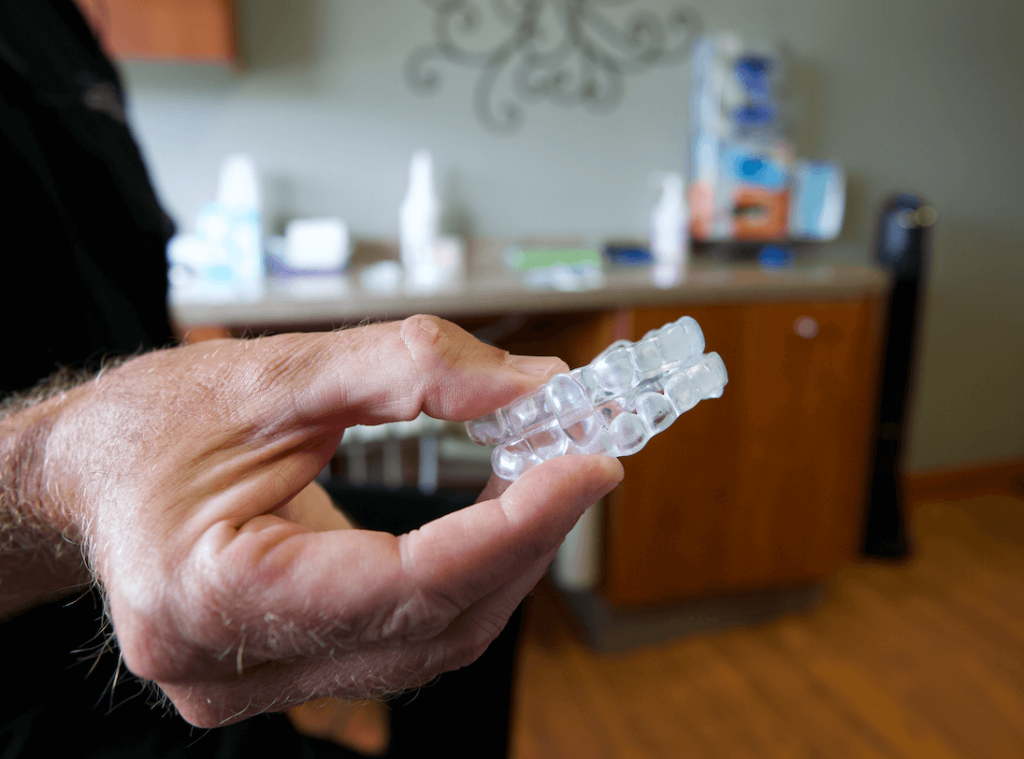 a dentist at Great Plains Dental holds a sleep appliance out